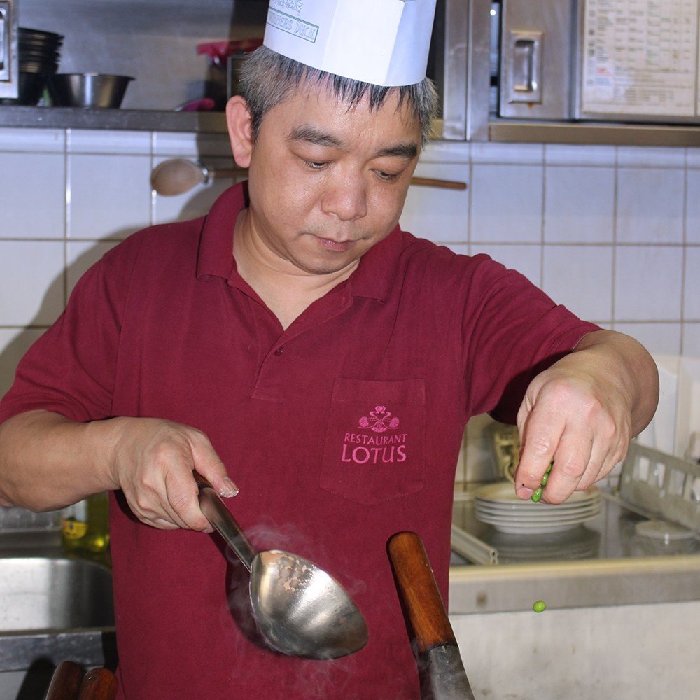 Chefkoch Hung Cao Ba am Herd, beim Anrichten mit der Kelle